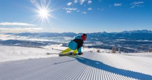 a man is skiing down a snow covered slope at Pension Fernsicht in Außerteuchen
