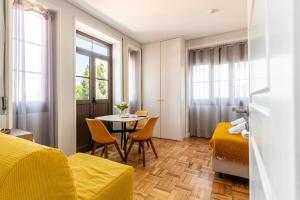 a room with two beds and a table with chairs at Magnolia Inn in Aveiro