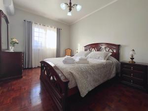 a bedroom with a bed and a dresser and a window at A Casa do Navio in Capelas