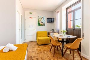 a small room with a table and a yellow chair at Magnolia Inn in Aveiro