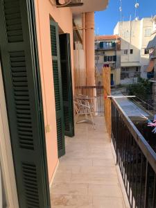 a balcony with green shutters on a building at Athina Central Corfu Town Apartment in Ágios Rókkos