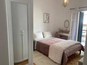 a bedroom with a bed and a table and a window at Athina Central Corfu Town Apartment in Ágios Rókkos