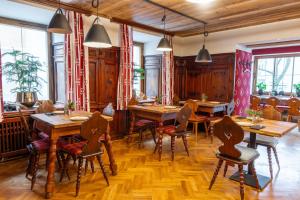 a restaurant with wooden tables and chairs and windows at GRETI - Alpine Boutique Hotel mit Alpentherme Eintritt, reichhaltigem Frühstück, Sauna in Bad Hofgastein