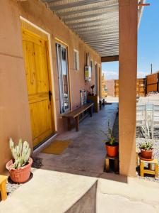 a building with a wooden door and potted plants at Casa Ñawi in San Pedro de Atacama