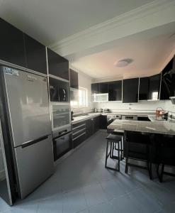 a kitchen with a stainless steel refrigerator and a table at Casa Sardine in Santo Isidoro +22 photos