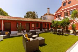 a house with a yard with green grass and furniture at Magnolia Inn in Aveiro