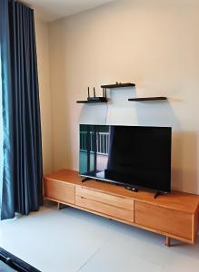 a flat screen tv sitting on top of a wooden entertainment center at Casa Amara in Ko Phangan