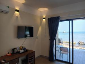a living room with a television and a view of the ocean at OCEAN DREAM-Beach House in Phú Quốc
