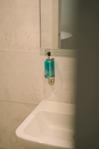 a bathroom sink with a soap dispenser on the wall at Hotel Aigue Marine in Tréguier +109 photos