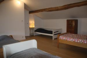 a living room with two beds and a dresser at Chez Combo in Saint-Estèphe