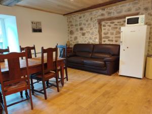 a living room with a leather couch and a table at Chez Combo in Saint-Estèphe