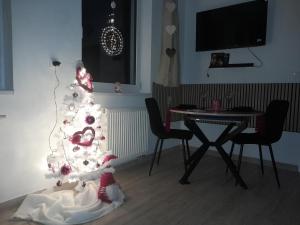 a christmas tree in a living room with a table at Biela Magnólia in Vrbov