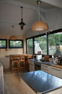 a kitchen with a counter and a table and some windows at Maison Claouey in Lège-Cap-Ferret