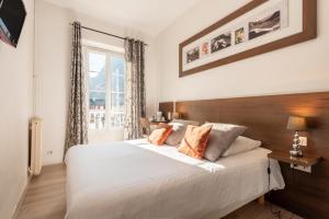 a bedroom with a large white bed and a window at Hôtel d'Ossau in Laruns