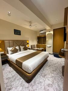 a hotel room with a large bed and a desk at Hotel Belleview VASTRAPUR in Jāmb +9 photos