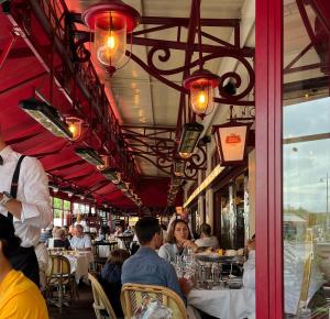 a group of people sitting at tables in a restaurant at le Pullman in Deauville