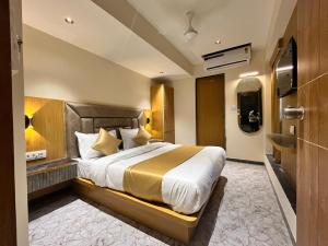 a hotel room with a large bed and a bathroom at Hotel Belleview VASTRAPUR in Jāmb