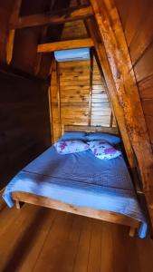a bed in the attic of a cabin at Chalé Fusinato in Witmarsum