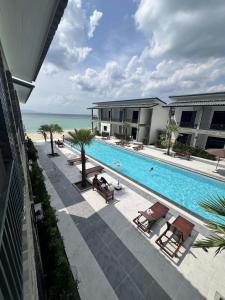 a swimming pool next to a building and the ocean at Double Rock Beach Hotel in Thong Sala