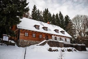 a log cabin with a snow covered roof at Chata Svahovka in Malá Morávka