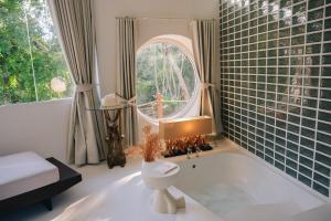 a bathroom with a tub and a toilet and a window at Mooncake house khaoyai in Ban Bung Toei +37 photos