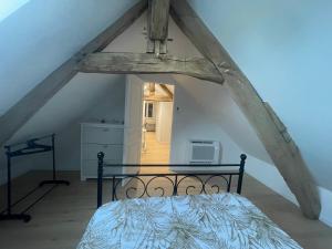a bedroom with a bed in an attic at Parenthèse au Gué des Archers maison climatisée in Saint-Valérien