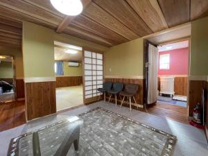 ein Wohnzimmer mit einem Glastisch und Stühlen in der Unterkunft まるごや 船でしか行けない離島の一棟貸し宿 in Hinase