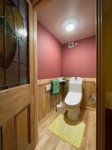 ein Badezimmer mit Toilette und einer rosa Wand in der Unterkunft まるごや 船でしか行けない離島の一棟貸し宿 in Hinase + 29 Fotos