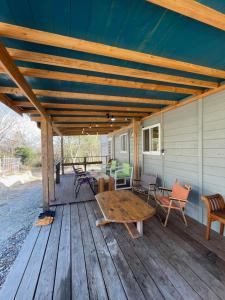 eine Holzterrasse mit einem Tisch und Stühlen darauf in der Unterkunft まるごや 船でしか行けない離島の一棟貸し宿 in Hinase