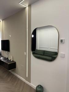 a living room with a mirror and a green couch at Apartament 2 camere Fial in Bacău