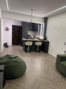 a living room with a table and two stools at Apartament 2 camere Fial in Bacău