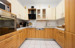 a kitchen with wooden cabinets and white appliances at House Villa Zvonko Near NP Krka in Sedramić