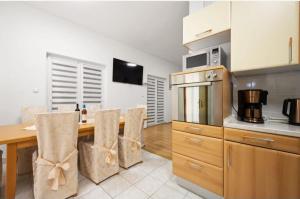 a kitchen with a wooden table and some chairs at House Villa Zvonko Near NP Krka in Sedramić
