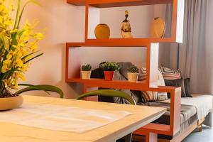 a table and a shelf with potted plants on it at Modernidade no Coração de Cuiabá in Cuiabá