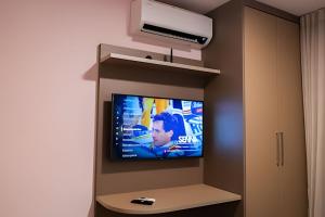 a flat screen tv on a wall in a room at Modernidade no Coração de Cuiabá in Cuiabá