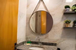 a bathroom with a sink and a mirror on the wall at Modernidade no Coração de Cuiabá in Cuiabá