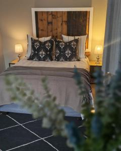 a bedroom with a bed with pillows and two lamps at Summerville Place in Addo