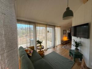 a living room with a couch and a large window at Kolmårdsgården B&B in Kolmården