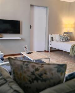a living room with a couch and a table at Summerville Place in Addo