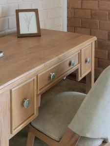 a wooden desk with a picture and a chair at Stay Zen in Arangala +4 photos