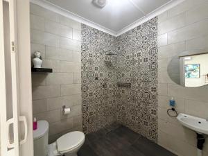 a bathroom with a toilet and a sink at The Guesthouse Klerksdorp in Klerksdorp +34 photos