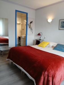 a bedroom with a large bed with a red blanket at Chez Les Papa's in Aspres-sur-Buëch