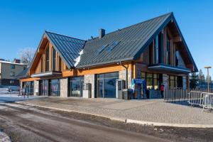 a building with a black roof on a street at Ski and Bike Residence in Istebna