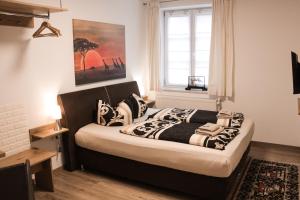 ein Schlafzimmer mit einem Bett mit schwarz-weißen Kissen in der Unterkunft Vila Belaggio in Plattling