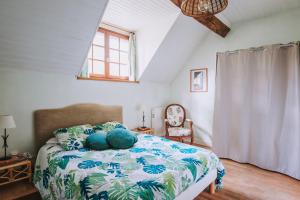 a bedroom with a bed with a blue and white comforter at Moulin de Vézelay - Maison d'hôtes in Fontenay-près-Vézelay