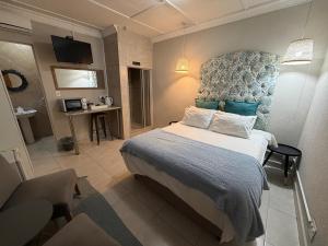 a bedroom with a bed with a blue headboard at The Guesthouse Klerksdorp in Klerksdorp