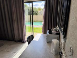 a room with a table with a view of a pool at The Guesthouse Klerksdorp in Klerksdorp