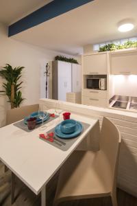 a white table with two plates on it in a kitchen at Casa Corallina Parma in Parma +13 photos