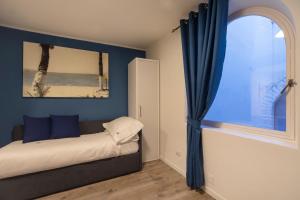 a bedroom with a bed with blue walls and a window at Casa Corallina Parma in Parma