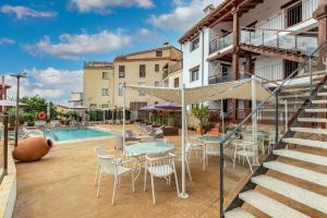 a patio with tables and chairs next to a pool at Natural&Mente Apartamentos Valle del Jerte in El Torno